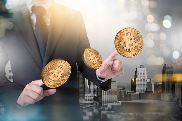 Business professional manipulating digital Bitcoin coins against urban cityscape background with bokeh lighting effects